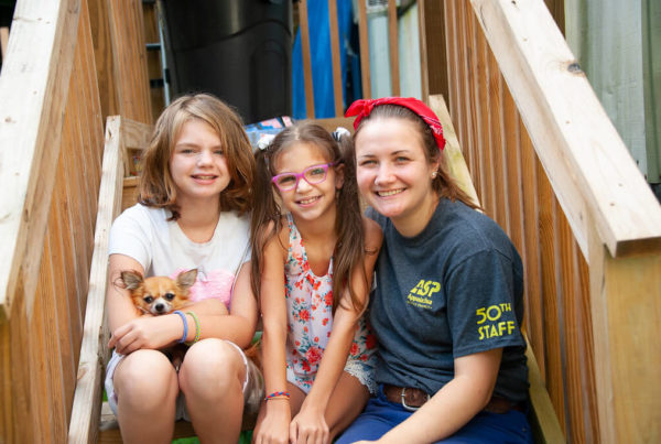female asp staffer with two kids sitting on a porch