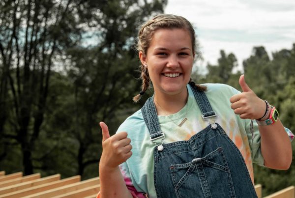 female college volunteer smiles while standing on roof