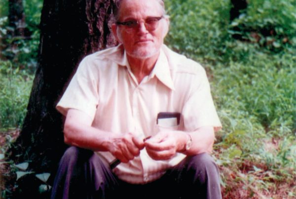 tex-evans-widdling-in-front-of-tree